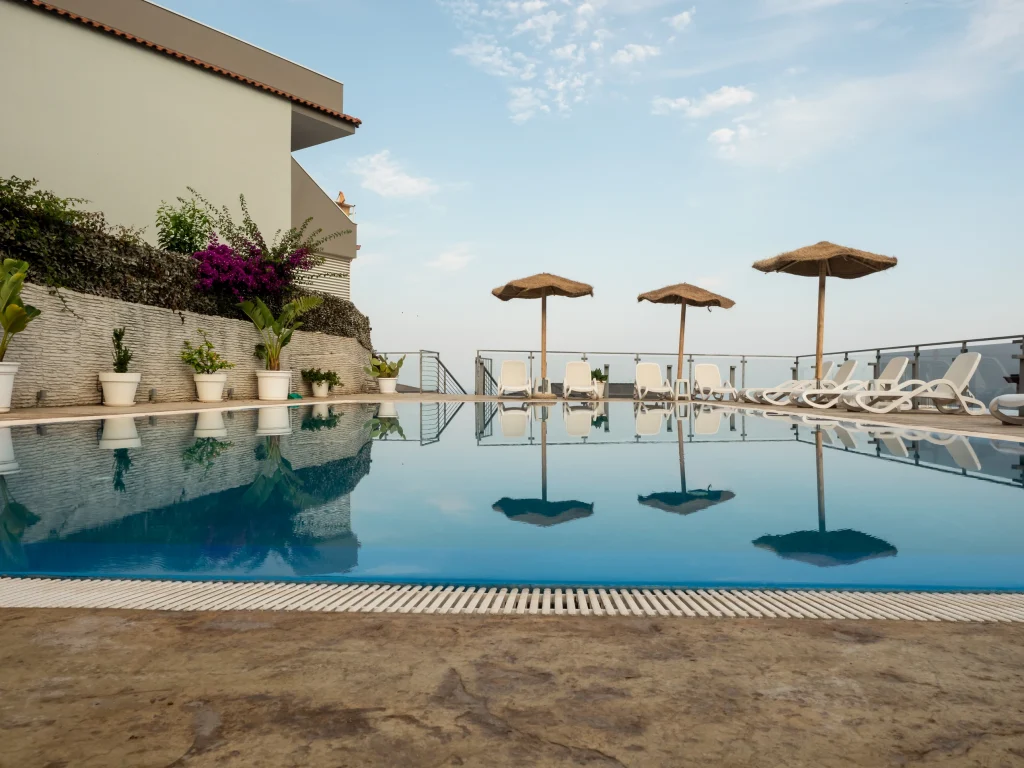 Grande piscina a sfioro dell'Airone Residence a Zambrone, un residence vicino Tropea pet friendly con area solarium, lettini e ombrelloni.