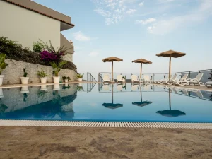 Grande piscina a sfioro dell'Airone Residence a Zambrone, un residence vicino Tropea pet friendly con area solarium, lettini e ombrelloni.