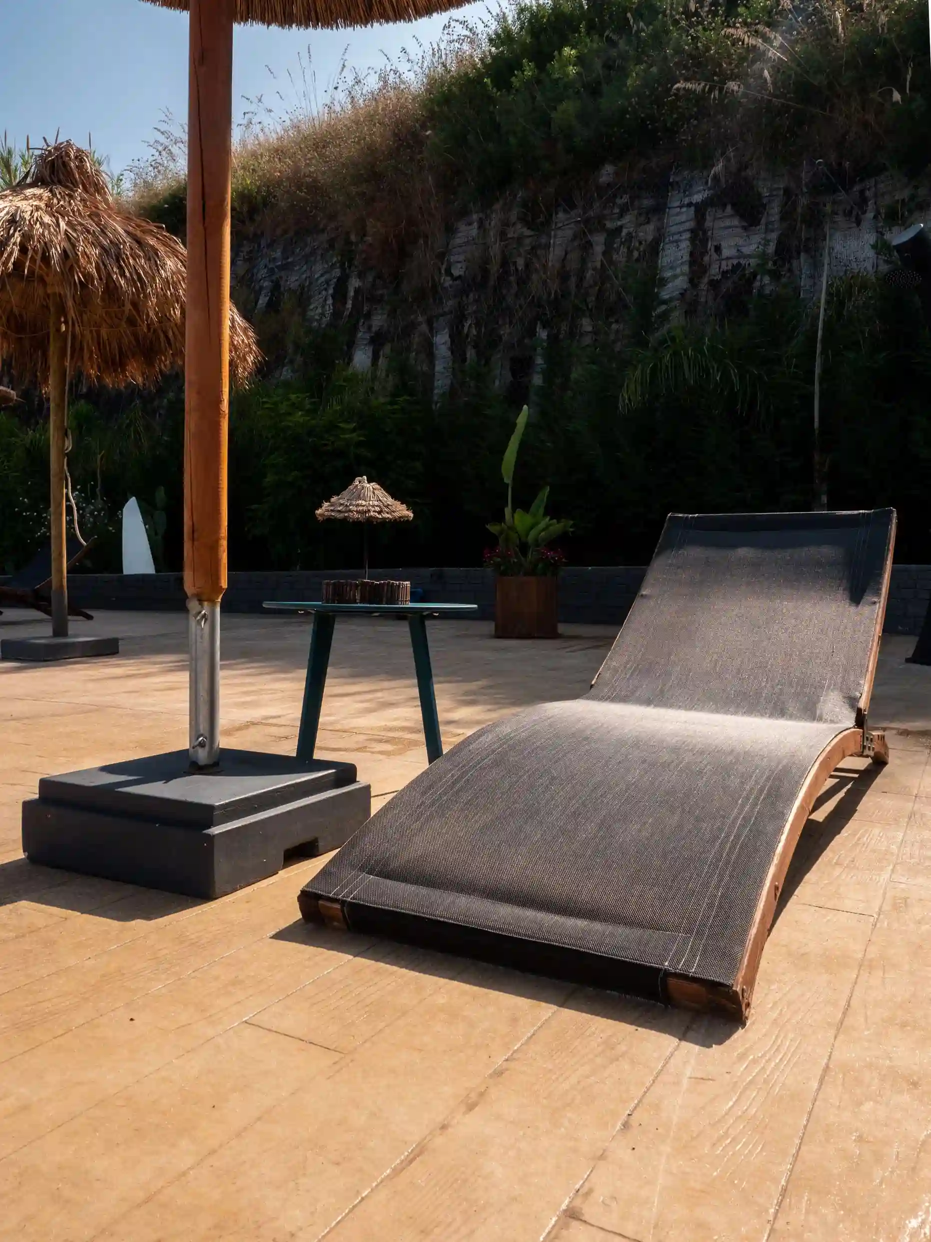 Sdraio ergonomica e ombrelloni in stile esotico nell'area solarium esterna dell'Airone Residence Zambrone.